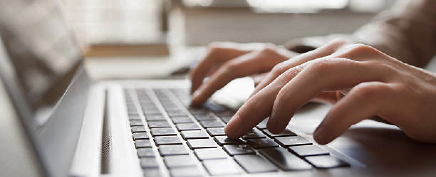 Closeup of hands typing at a laptop